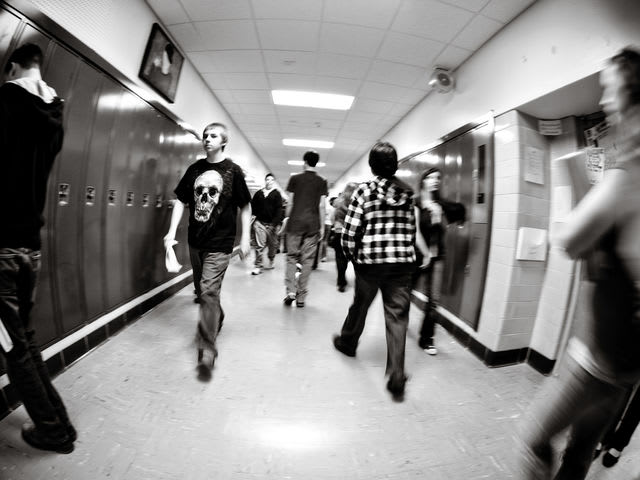 Someone trips in front of you in the hallway at school, you...