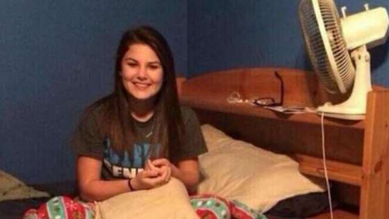 A man came home early from a business trip to find his wife sitting politely in bed. He took a photo of her to capture her surprise about his early return. 
