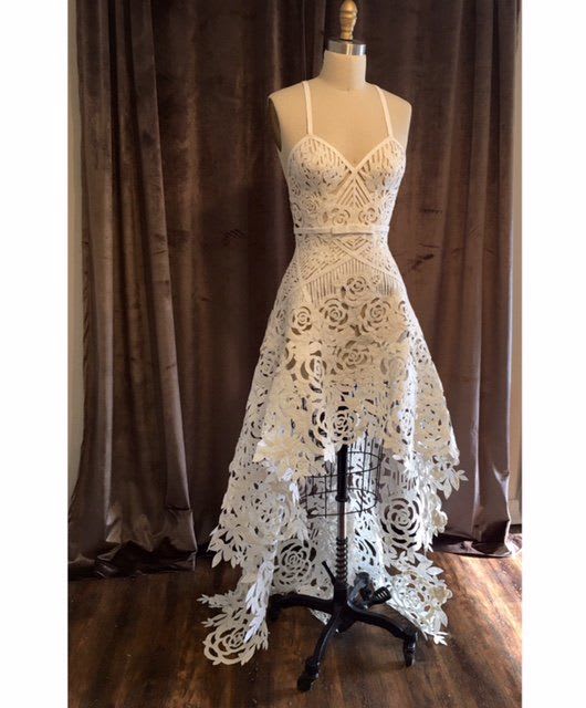 This unbelievable sheer gown submitted by Ashley Ulcini Cobb features geometric and rose cutouts throughout and rides the trend of high-low skirts flawlessly. The sharp bow belt detail at the front of the dress only adds to its uber-detailed perfection.
