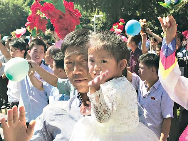  Balões, buquês de flores e milhares de pessoas nas ruas de Pyongyang para saudar os militares 