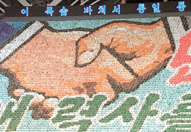 Aperto de mãos entre os presidentes das duas Coreias foi representado no gigantesco mosaico humano dos Mass Games  