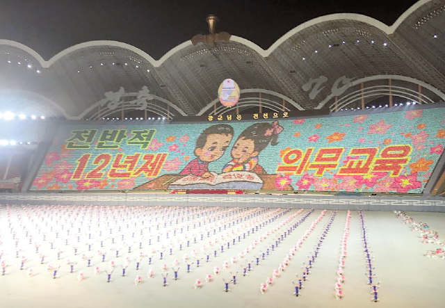 Durante o  Mass Games, a exaltação da obrigatoriedade do ensino por 12 anos 