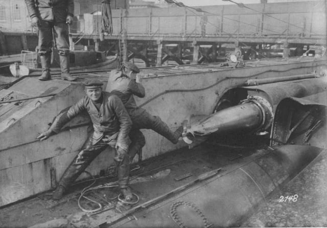 Unos técnicos alemanes cargan un torpedo en su lanzadera. 
