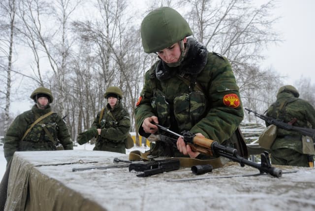 Un soldado ruso ensambla un fusil de asalto Kalashnikov AKM. 
